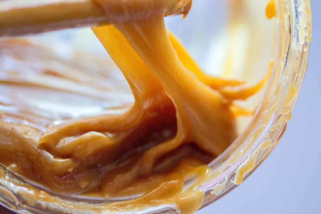 Fond de pot de caramel au beurre salé avec texture liquide et couleur dorée